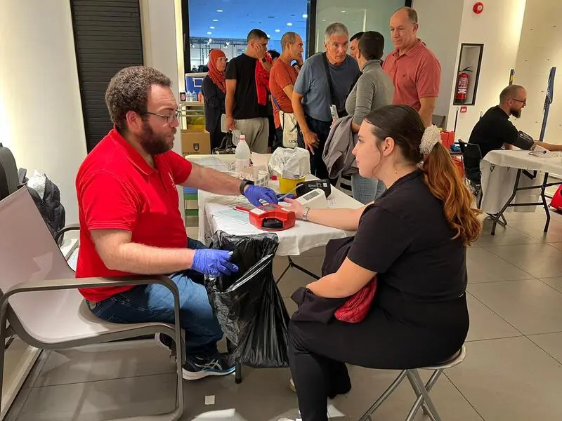 Una mujer recibe las &uacute;ltimas instrucciones antnes de donar delante de una impresionante cola/ Dani Hern&aacute;ndez