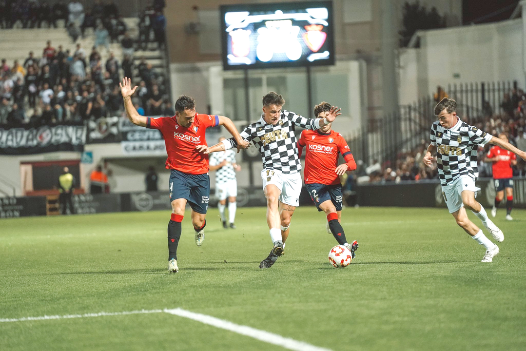 Aquino, jugador de la AD Ceuta FC, pelea el bal&oacute;n ante la zaga de Osasuna