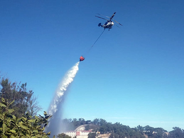 El Helicóptero descarga agua sobre el fuego / Juanjo Coronado