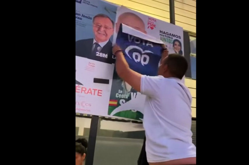 Un militante del PP tapa un cartel electoral de Gutiérrez/ Foto: PSOE