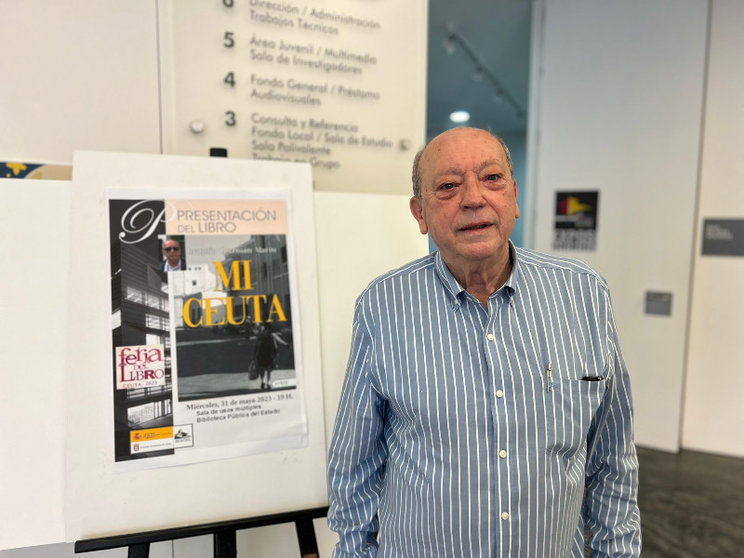 Joaquín Guzmán posa junto al cartel de su libro/ Foto: Dani Hernández