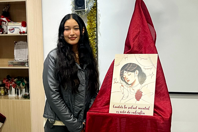 La ganadora posa junto al cartel por el que se ha llevado este reconocimiento