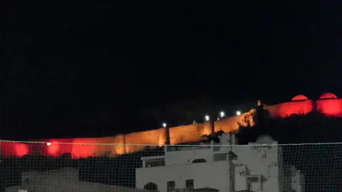 Los colores de la bandera nacional iluminan la fortaleza del Hacho / Rafa B&aacute;ez