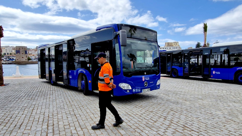 Un conductor pasea por delante de uno de los autobuses urbanos de Ceuta/ Archivo