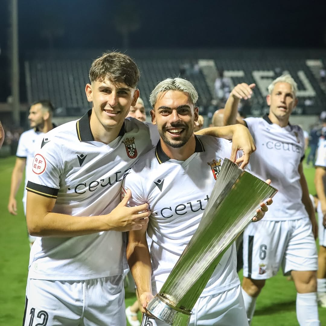 Víctor Corral y Jacobo posando con el trofeo de campeones de Primera Federación.